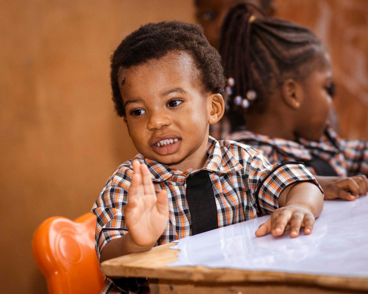 Two young children enjoy a fun interactive session in their classroom, expressing joy and engagement.