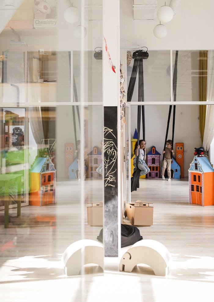 Children engaging in play with colorful toys in a bright, modern kindergarten classroom.